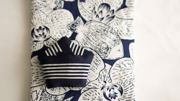 Una prenda doblada con estampado floral y un artículo a rayas encima.