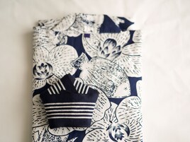 Una prenda doblada con estampado floral y un artículo a rayas encima.