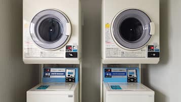Deux machines à laver à chargement frontal identiques, dotées de panneaux de commande et de distributeurs de lessive situés en dessous.