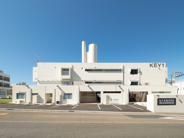 A modern building with a prominent 'KEY1' sign, a parking area, and a 'SEAMORE RESIDENCE' sign. - Shirahama Key Terrace Seamore Residence (Shirahama)