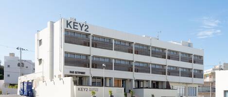 A modern multi-story building with a sign reading "KEY2" and "BAR KEYPOINT".