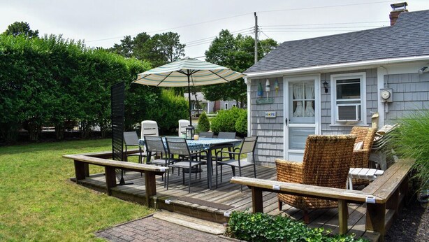 Eine Terrasse mit Tisch, Stühlen und Sonnenschirm, sowie ein Holzdeck.