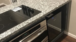 A kitchen with a granite countertop, stainless steel appliances, and a built-in oven. - Charming Heights Guesthouse! (Houston)