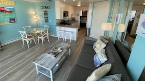 A compact living space with a dining area, kitchen, and a sofa with decorative pillows. - Find your beach bliss! (San Diego)