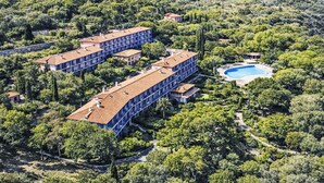 A hotel with multiple buildings, a swimming pool, and a mountainous backdrop. - Mimose 2 by Interhome (Rio Marina)