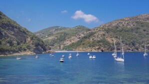 A coastal area with clear blue water and boats anchored near the shore. - Mimose 2 by Interhome (Rio Marina)