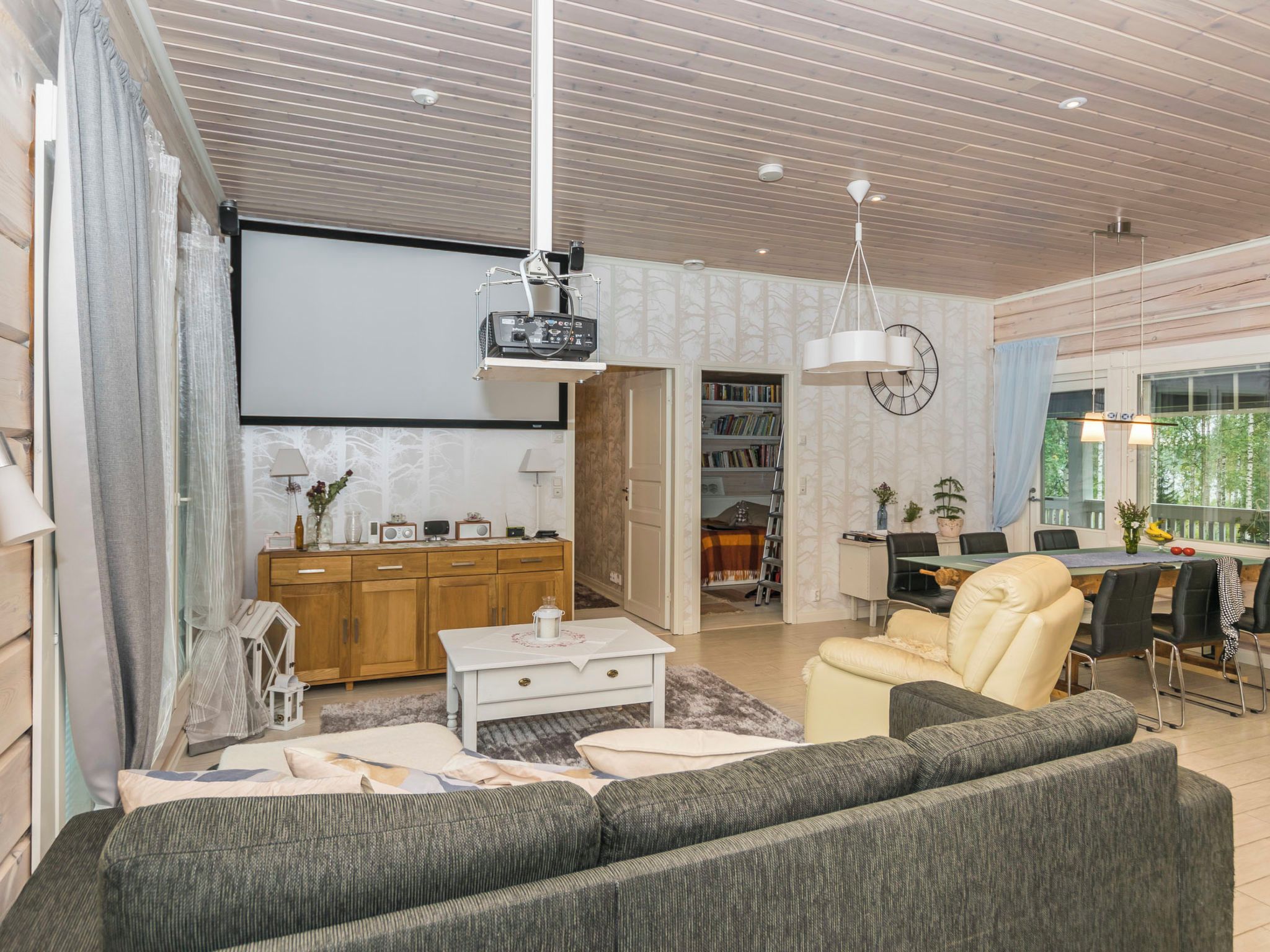 Ein modernes Wohnzimmer mit einer Couch, einem Couchtisch und einem an der Wand montierten Fernseher.