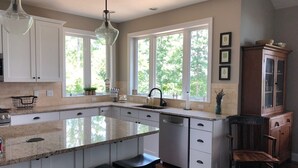 Una cocina amplia con una isla grande, armarios blancos y un mueble de madera.
