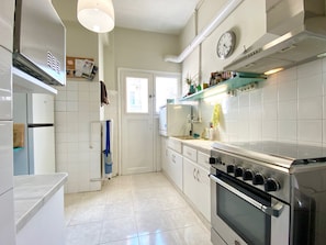 A kitchen with white cabinets, a stainless steel oven, and a window.