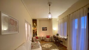 A cozy living room with a sofa, a coffee table, a dining table, and a chandelier. - Sunny Apartment (90m2) in Athens center (Athens)