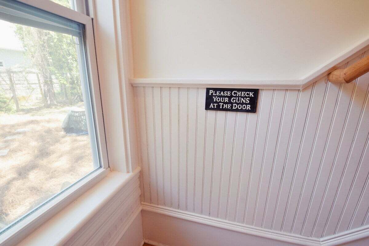 Une pancarte sur un mur porte l’inscription : « Veuillez déposer vos armes à l’entrée. »