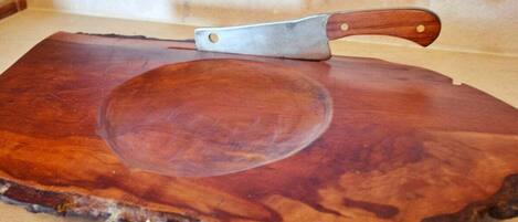 Una tabla de madera con un cuchillo sobre una encimera de cocina.
