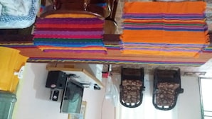 Une pièce qui contient une chaise en bois, un téléviseur et une paire de sandales.