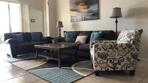 A living room with a sofa, armchair, coffee table, and two lamps. - Disney great escape! Wheelchair accessible villa (Davenport)