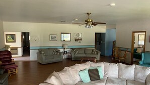 A spacious living room with a large beige sectional sofa, two grey sofas, a wooden coffee table, and a ceiling fan. - Behnke's Country Center, Reedsville WI. EAA, Green Bay Packers, Road America (Reedsville)