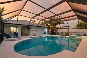 Una piscina con una estructura de sombrillas, sillas de descanso y vistas al cielo.