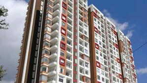 A high-rise residential building with multiple balconies, a modern entrance, and a visible parking area. - Aparta Suite Ventus (Tunja)