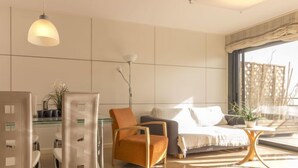 Una camera da letto moderna con un letto, una sedia, un tavolo e un'ampia finestra.