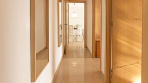Un corridoio con porte in legno e specchi alle pareti.