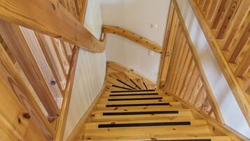 A wooden staircase with a handrail and a landing area.