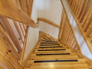 Una escalera de madera con barandilla y un rellano.