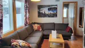 Uma sala de estar com sofá, mesa de centro e um quadro na parede.