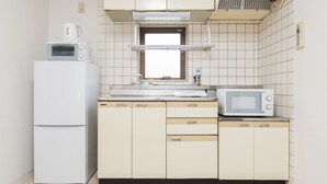 Un angolo cottura compatto con frigorifero, forno a microonde e un piccolo lavello.