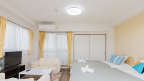 Camera d'albergo con un letto, un divano, una televisione e un condizionatore.