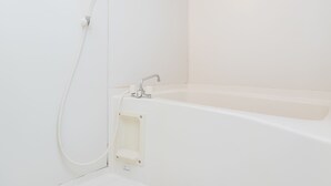 Un bagno bianco con una vasca e una doccia.