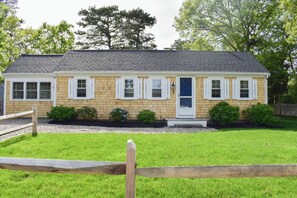 Stunning two-story home with a brick and siding facade, featuring a charming porch and beautifully manicured lawn.