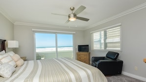 A bedroom with a bed, a television, a chair, and a ceiling fan. - Oceanfront South Mission Beach Vacation Rental on the Sand 2737 (San Diego)