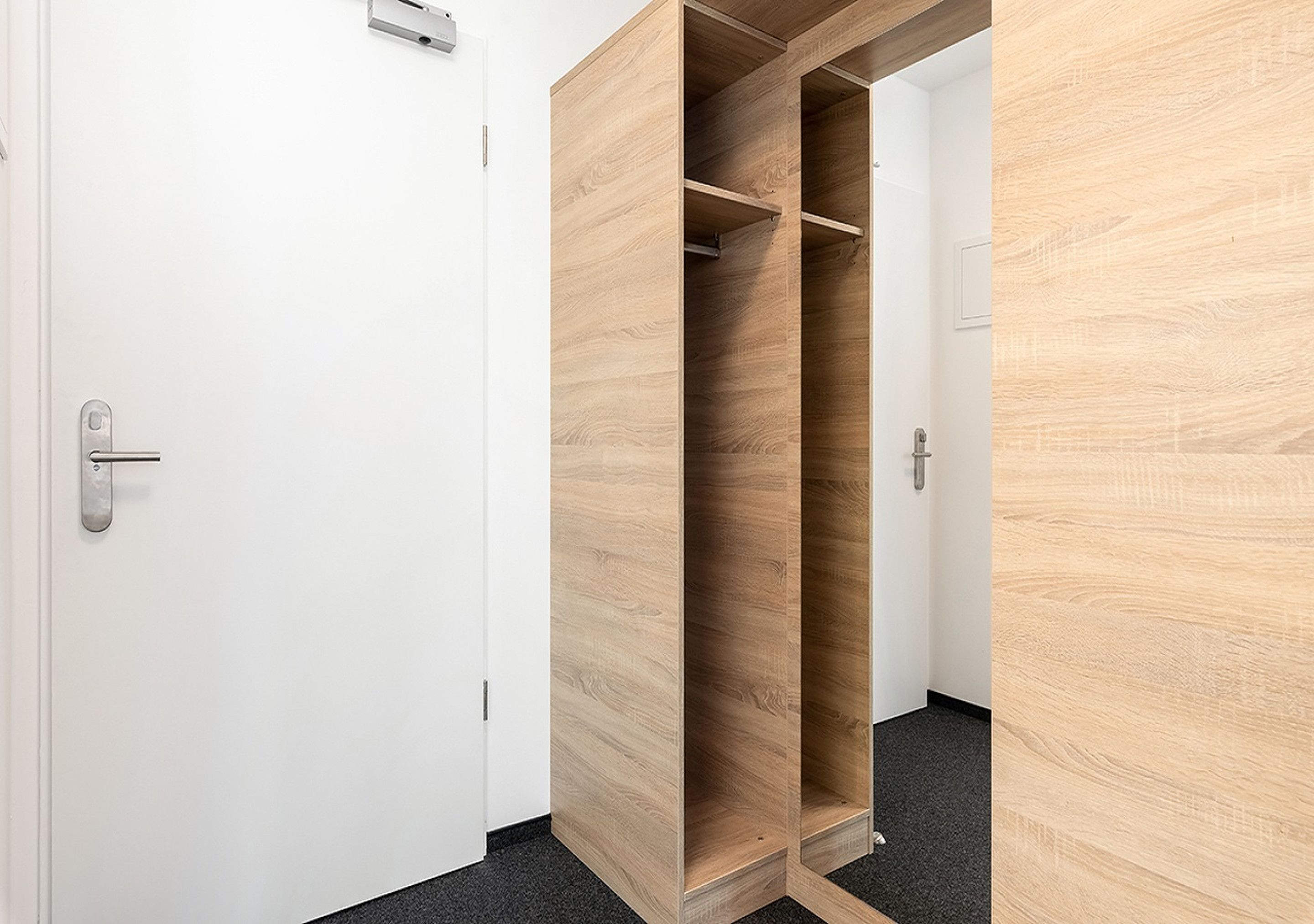 Une pièce avec une armoire en bois et une porte blanche.