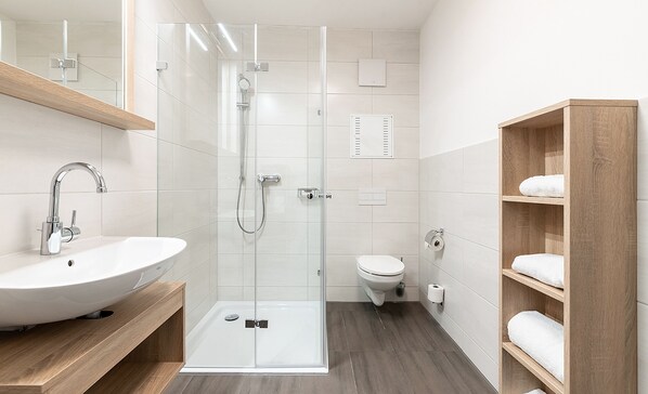 Executive appartement | Badkamer | Een douche, handdoeken, toiletpapier