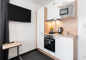 Studio | Privékeuken | Een koelkast, een microgolfoven, een oven, een kookplaat