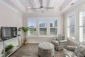 Enjoy a room with a large window offering views of the surrounding area, a seating area with a chair and ottoman, and a flat-screen TV.