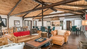A spacious living area with leather sofas, a wooden coffee table, and a high wooden ceiling. - Luxury Mountain Retreat Near Estes Park Stunning Views, Perfect Family Getaway (Allenspark)