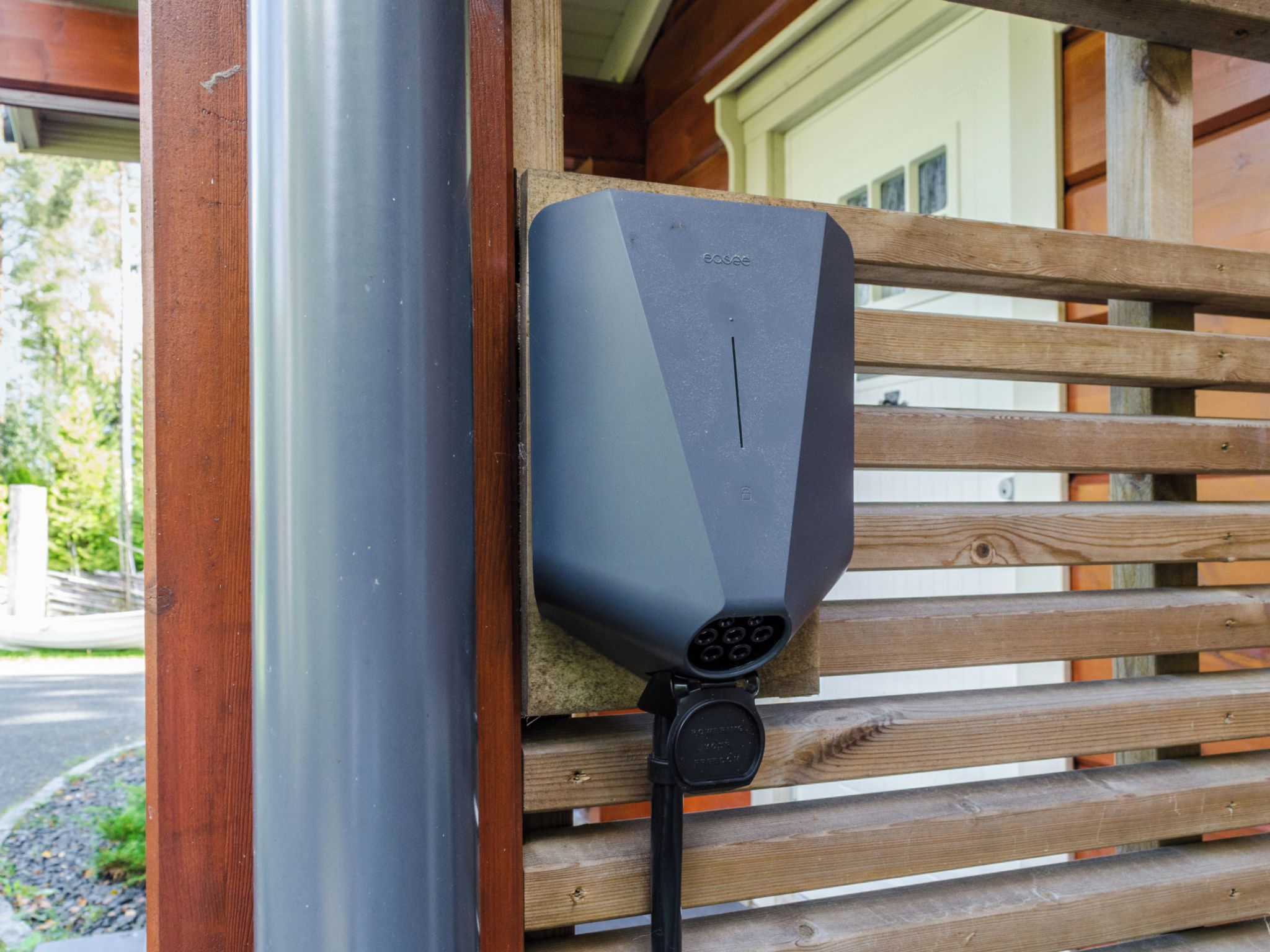 A charging station mounted on a wooden fence.
