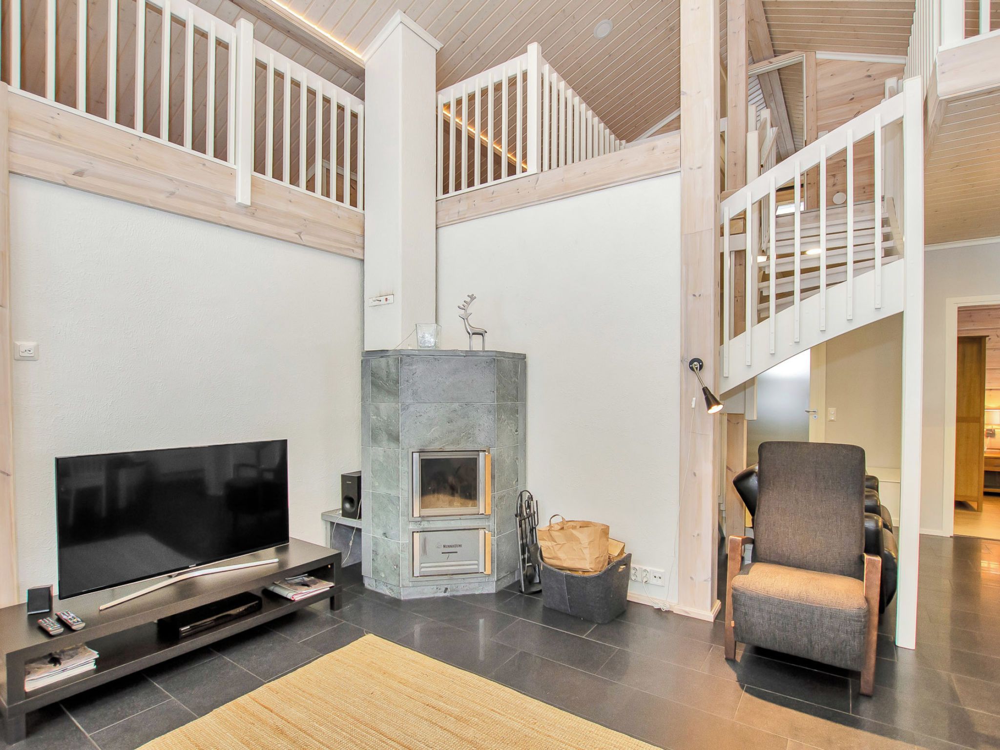 A spacious living area with a fireplace, a television, and a comfortable chair.