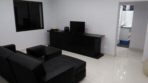 A modern living room with black furniture, a flat-screen TV, and a small cabinet. - Atlantic view with free car and bike.  (Gaula)
