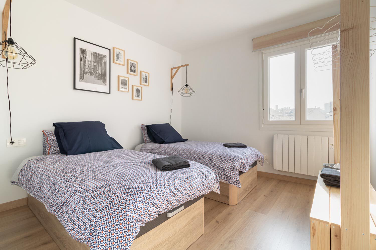 Een kamer met twee bedden, een raam en een radiator.