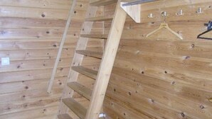 A wooden interior with a sloped ceiling and a metal railing. - Herkkola by Interhome (Taivalkoski)
