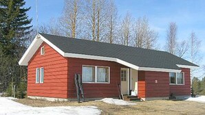 A red single-story house with a gabled roof, a front porch, and a small front yard. - Herkkola by Interhome (Taivalkoski)