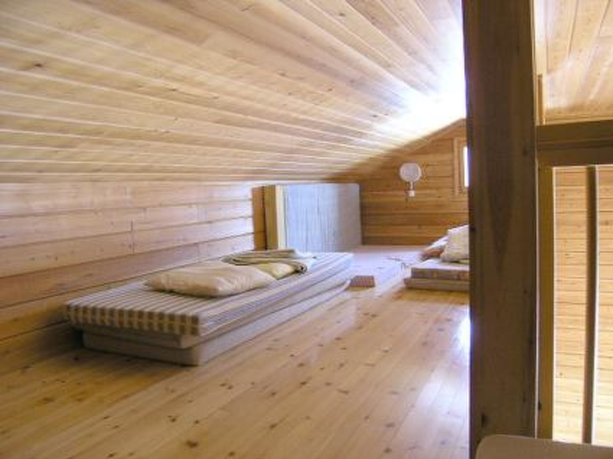 Un intérieur en bois avec un lit superposé, une petite table et une fenêtre.