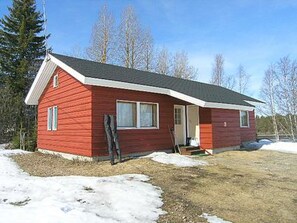 A small, single-story red cabin with a gabled roof, a front porch, and a visible door. - Herkkola by Interhome (Taivalkoski)