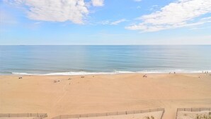 Una playa con cielo despejado y mar en calma.