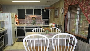 Enjoy meals in the kitchen with a central island and dining area, featuring a stove, refrigerator, and table with chairs.
