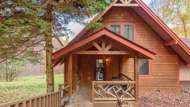 A wooden cabin with a porch, a staircase leading to the entrance, and a view of the surrounding trees. - Relax at the Read Retreat-ready to host families all 4 seasons (Beech Mountain)