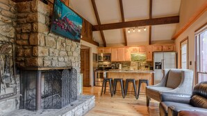 A stone fireplace, wooden beams, a kitchen with a stone backsplash, and a bar area with stools. - Relax at the Read Retreat-ready to host families all 4 seasons (Beech Mountain)
