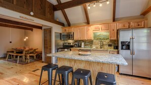 A kitchen with wooden cabinets, a granite countertop, a stainless steel refrigerator, and a stone backsplash. - Relax at the Read Retreat-ready to host families all 4 seasons (Beech Mountain)