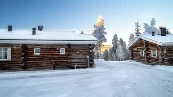 A log cabin with a snow-covered roof and a clear sky.